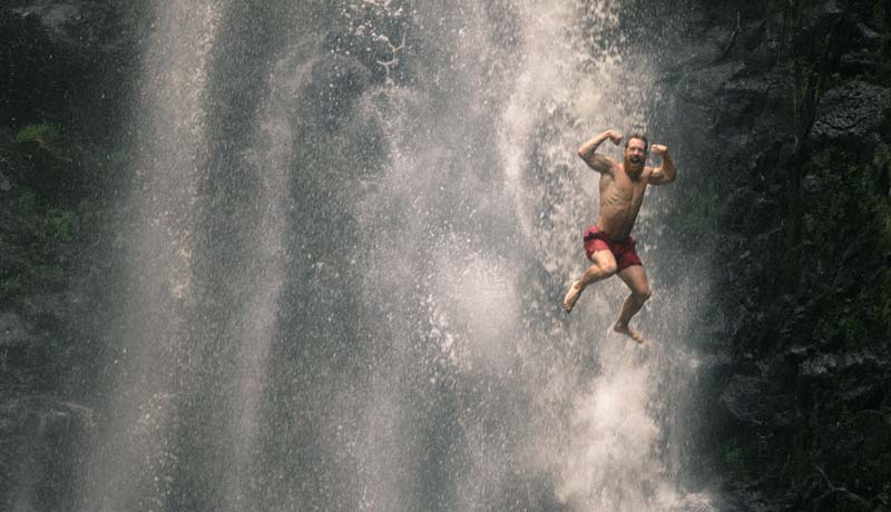 Physical health - man jumping at waterfall